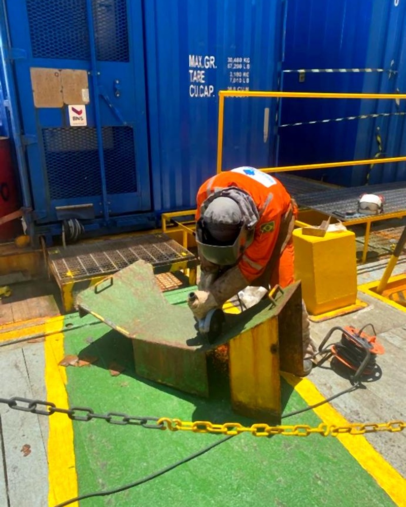 Técnico realizando preparação de superfície em peça metálica em deck